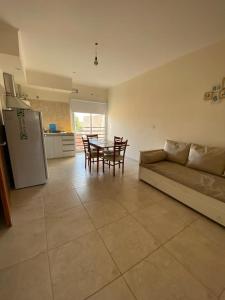 Una sala de estar con un sofá y una mesa y una cocina. en Espacio Millán, en Concepción del Uruguay