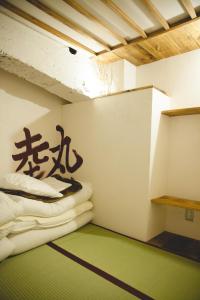 a room with two beds and a green floor at Guest House MARUYA in Atami