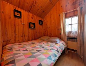 Un dormitorio con una cama en una pared de madera. en Le petit chalet de Cabourg, en Cabourg