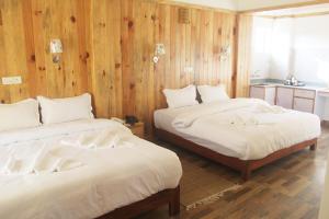 two beds in a room with wooden walls at Tristar Hotel in Pokhara