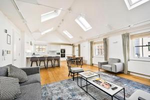 a living room with a couch and a table at Spacious Fitzrovia Apartment 3 Bed in London