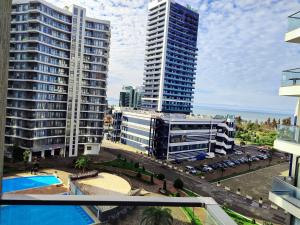 a view of two tall buildings in a city at Bright large apartment in White Sails in Batumi