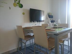 ein Esszimmer mit einem Tisch mit Stühlen und einem TV in der Unterkunft Apartment Punta in Sukošan