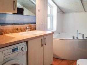 ein Badezimmer mit einem Waschbecken, einer Badewanne und einer Waschmaschine in der Unterkunft 6 person holiday home in GROEMITZ in Grömitz + 24 Fotos