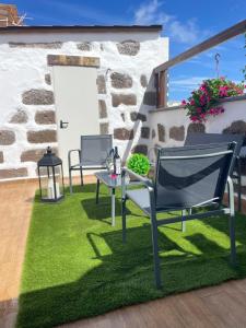 un patio con sedie e un tavolo sull'erba di Casa La Candelaria - Moya a Moya