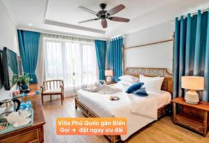 Un dormitorio con una cama grande con cortinas azules. en Villa Phú Quốc Gần Biển, en Phu Quoc