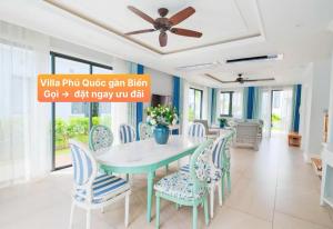 Un comedor con una mesa y sillas azules. en Villa Phú Quốc Gần Biển, en Phu Quoc