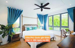Un dormitorio con una cama y un ventilador de techo. en Villa Phú Quốc Gần Biển, en Phu Quoc 10 fotos más