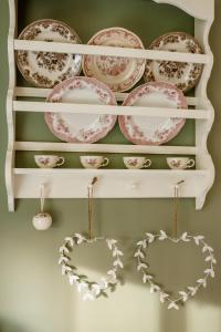 a shelf with plates and hearts on it at Omulīgs mājoklis Ogres sirdī in Ogre