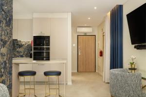 a kitchen with two stools and a counter in a room at Safira Suites 301 in Funchal