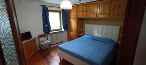 a bedroom with a blue bed and a window at La Sosta1-2 in Arliod