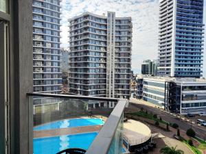 a view from the balcony of a building with a pool at Bright large apartment in White Sails in Batumi