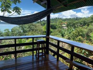 a hammock on a deck with a view of the ocean at Vista Drake Lodge in Drake Bay Airport
