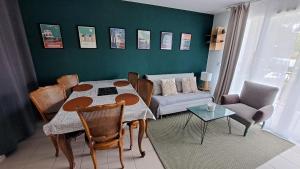 a living room with a table and a couch at L'airial de Laure in Ondres