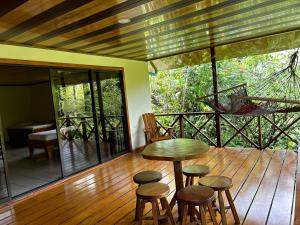 a porch with a table and stools on a deck at Vista Drake Lodge in Drake Bay Airport