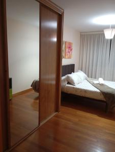 a bedroom with a bed and a sliding glass door at Piso ABELEDO in Sarria +4 photos