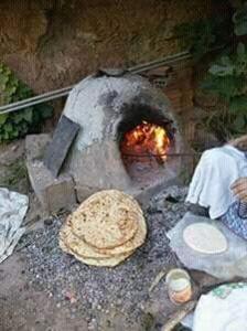 a stone oven with a pizza sitting on the ground at KASBAH DES MONTAGNS maisons d'hôtes la vallée des roses in Bou Tharar