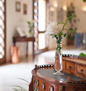a vase with a white rose sitting on a table at Torre Bennistra in Scopello