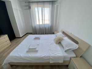 a bedroom with a large bed with white sheets and towels at Apartament cu 2 odai Testemiteanu in Chişinău