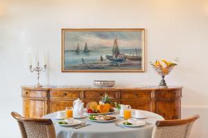 a dining table with fruit and a painting on the wall at Torre Bennistra in Scopello