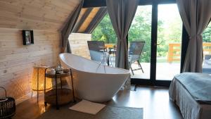 a large bath tub in a room with a bedroom at Kavics Kabin in Nagymaros