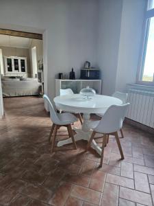 a dining room with a white table and chairs at Suites Palazzo Ianni in Vallerano +20 photos