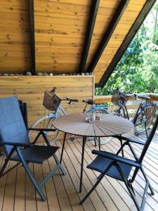 a table and chairs on a deck with a bike at Kavics Kabin in Nagymaros