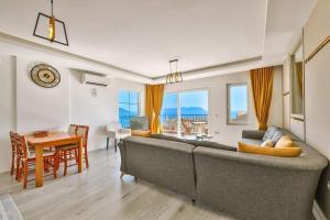 a living room with a large couch and a dining room at Ozy Houses Center in Kaş