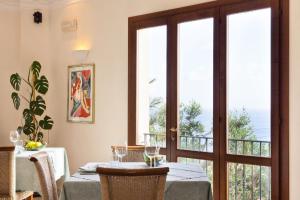 a dining room with a table and a glass door at Torre Bennistra in Scopello