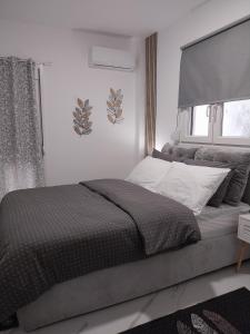 a bedroom with a bed and a window at ThessVibe Home in Thessaloniki