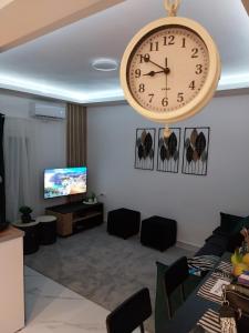 a large clock hanging on a wall in a living room at ThessVibe Home in Thessaloniki