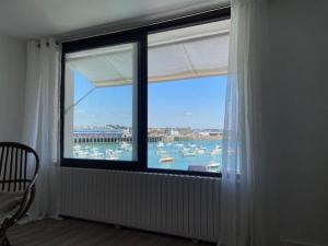 a window in a room with a view of a harbor at Côté Port in Granville