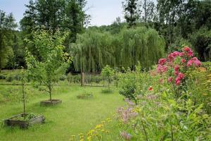 einen Garten mit zwei Bäumen und Blumen im Gras in der Unterkunft Chambres indépendantes de charme à proximité d'Amboise in Pocé-sur-Cisse