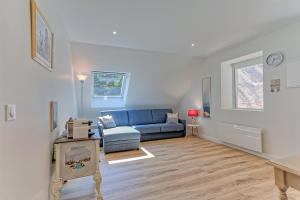 ein Wohnzimmer mit einem blauen Sofa und einem Fenster in der Unterkunft Chambres indépendantes de charme à proximité d'Amboise in Pocé-sur-Cisse