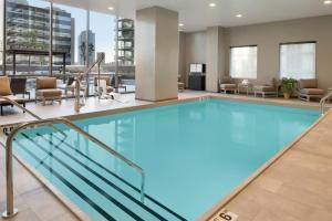 芝加哥Homewood Suites by Hilton Chicago West Loop Fulton Mkt Area的酒店大堂的游泳池，配有桌椅