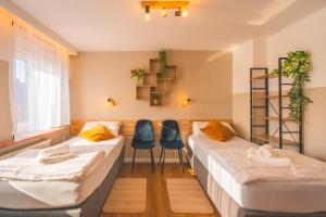 two beds in a room with two chairs at Sleeping Home - Red House - Großes Haus für Gruppen mit 2 Wohnungen - 15 Betten - 2 Küchen - Parkplätze - Self Check-in in Bielefeld