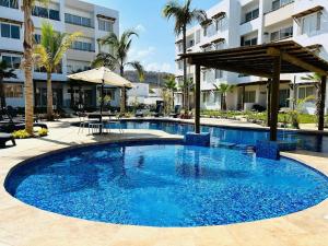 ein großer blauer Pool in einem Resort mit einem Gebäude in der Unterkunft cómodo con alberca cerca de la playa by G P S rentas in Mazatlán