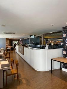 een restaurant met een witte bar en tafels en stoelen bij Landscape VIP Fortaleza in Fortaleza