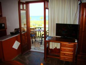 a living room with a television and a view of the ocean at Drapania Beach Marinakis in Kissamos