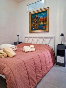 a bedroom with a red bed with two towels on it at Sanremo Apartments - Il Vicoletto in Sanremo
