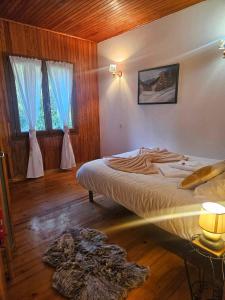 a bedroom with a bed and two windows at Le chalet des Ecureuils - Vue imprenable sur la Dent du Chat in Saint-Jean-de-Chevelu
