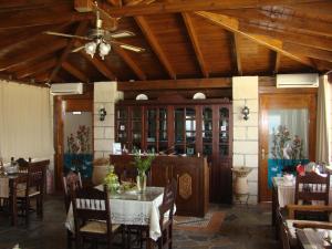 a dining room with a table and a ceiling fan at Drapania Beach Marinakis in Kissamos