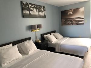 a bedroom with two beds and a lamp at Annapolis Royal Inn & Suites in Annapolis Royal +41 photos