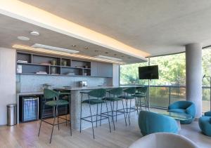 a kitchen with a bar with green chairs and a tv at Setai Yacht by DayByDay in João Pessoa +18 photos
