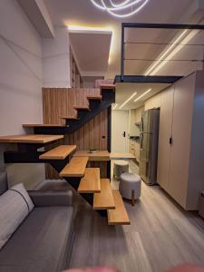 een woonkamer met trap en een bank en een keuken bij Espaço Versa Brooklin in Sao Paulo