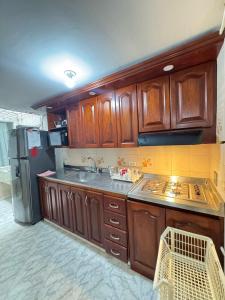 a kitchen with wooden cabinets and a stainless steel refrigerator at Apartamento Edificio Parques Del Trianon in Envigado +5 photos
