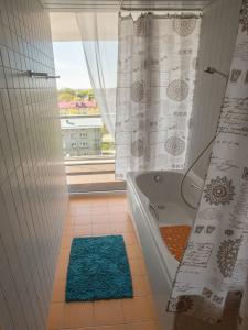 La salle de bains est pourvue d'une baignoire et d'une fenêtre. dans l'établissement Apartment Suvekorter Aida, à Pärnu