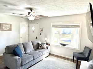 a living room with a couch and a ceiling fan at Private Ranch - Entire Home - 3 Bed Room - Hot Tub - King Bed - Fenced Yard - Pets & Kids Welcome - Game Shed - Free WiFi in Columbus