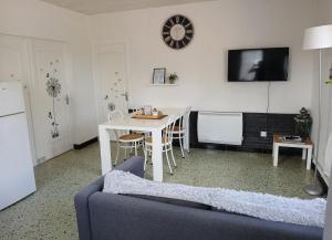 a living room with a couch and a table and a tv at La maisonnette in Cléry-Saint-André