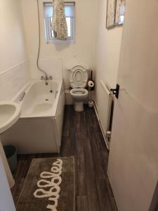 a bathroom with a tub and a toilet and a sink at The Warren in Skegness